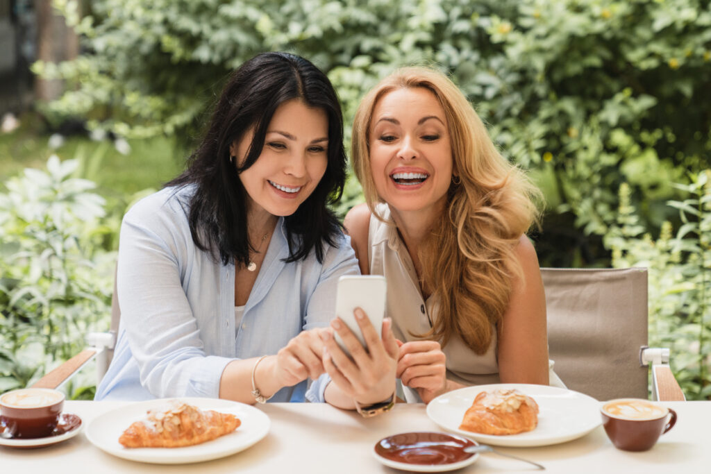 Cheerful smiling laughing two caucasian middle-aged women best friends businesswomen